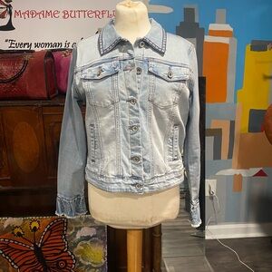 A denim jacket with embellishments on the back with pearls